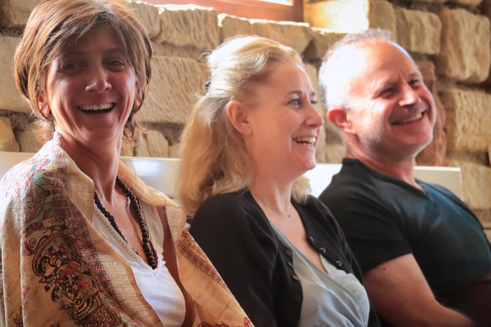 Trois participants rient ensemble pendant le stage